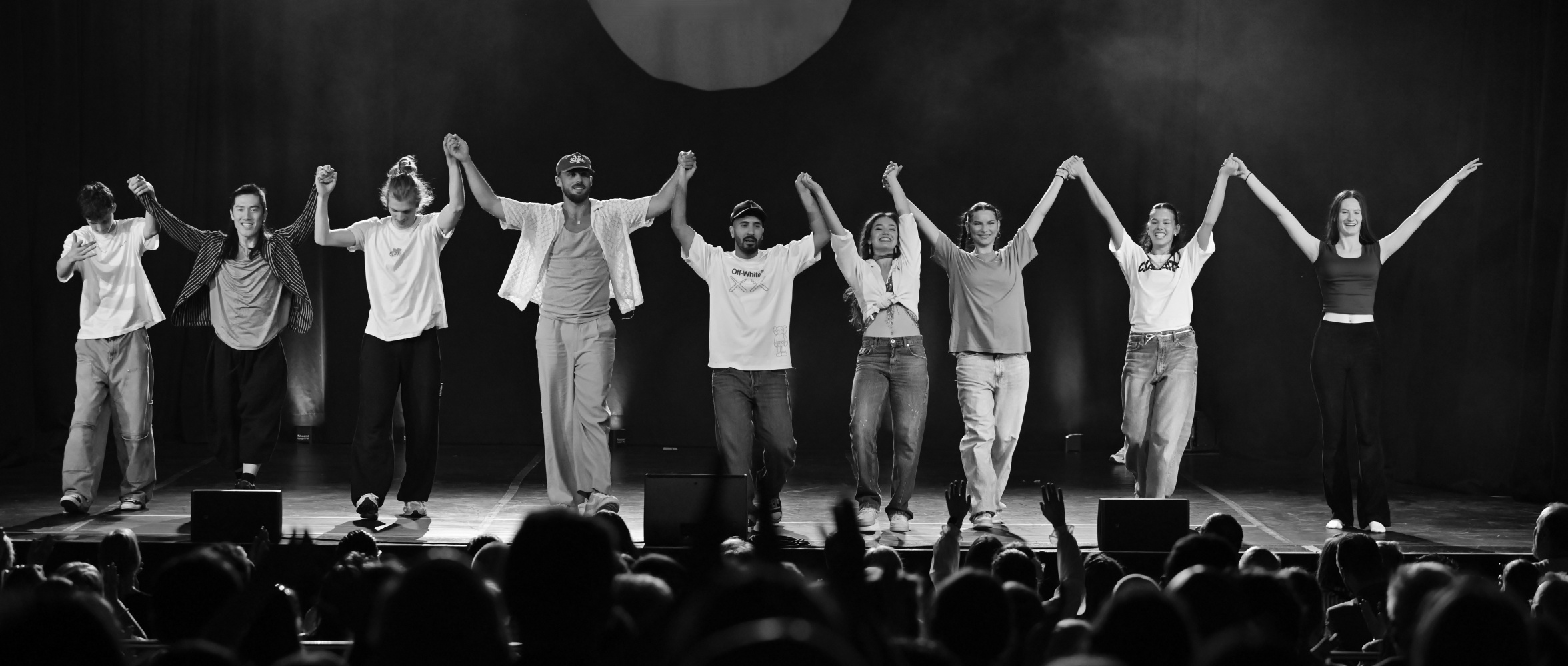 NAF DANCE Team auf der Bühne – Coaches heben gemeinsam die Hände als Zeichen von Zusammenhalt