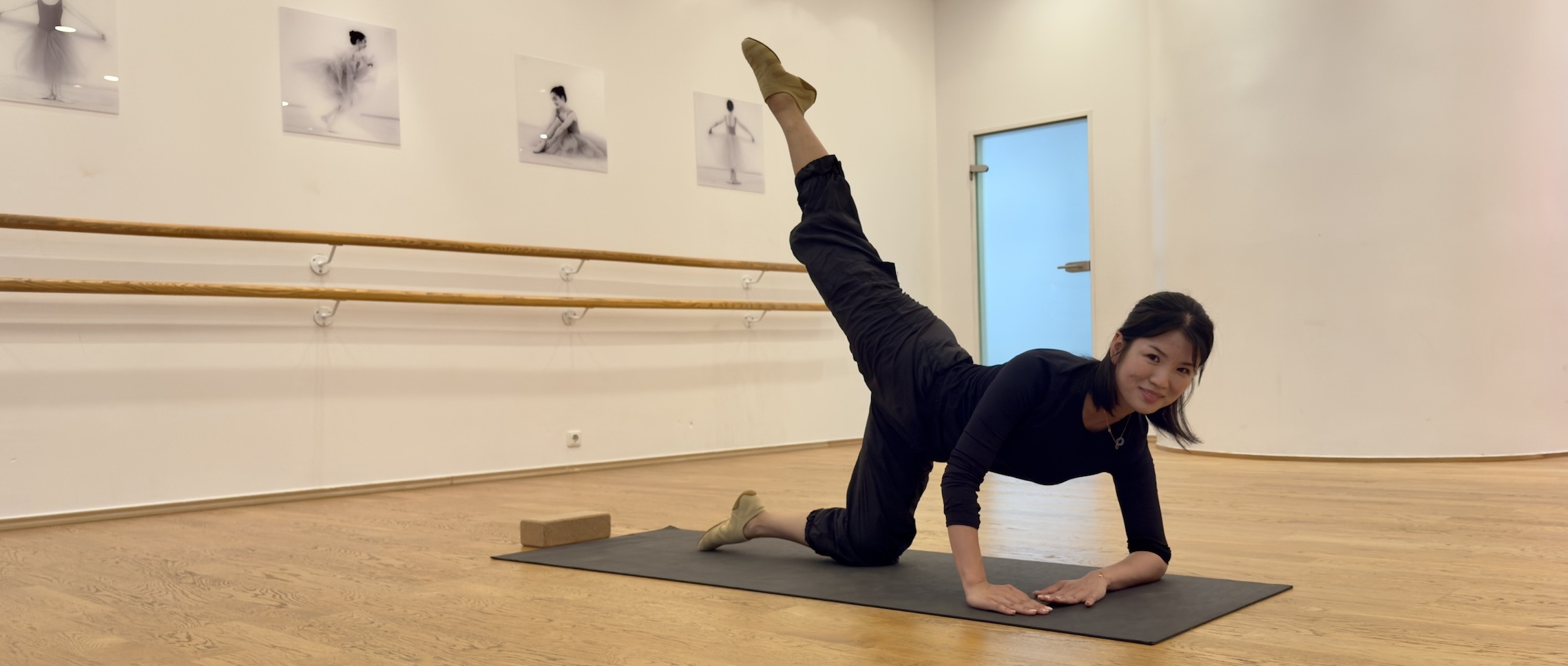 Tänzerin auf Matte beim Barre-Ballett-Workout – Training für Kraft, Haltung und Balance in der Tanzschule Köln.